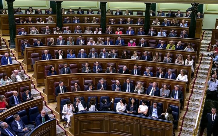 Fotografía editorial que muestra el hemiciclo del Congreso de los Diputados durante una sesión plenaria con los diputados en sus escaños.