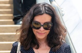Silvia Bronchalo con gafas de sol oscuras y blusa de lunares caminando por unas escaleras exteriores.