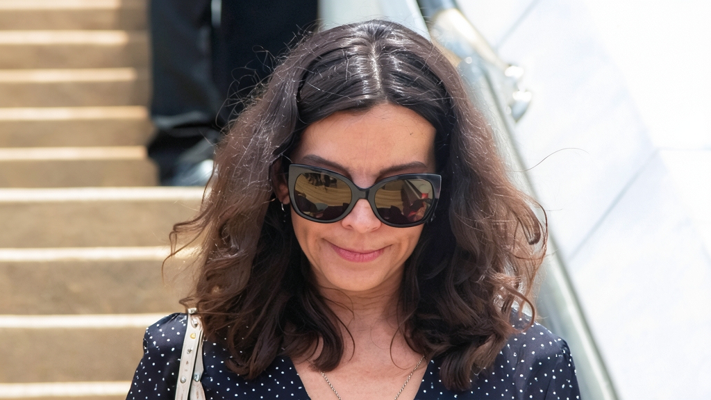 Silvia Bronchalo con gafas de sol oscuras y blusa de lunares caminando por unas escaleras exteriores.